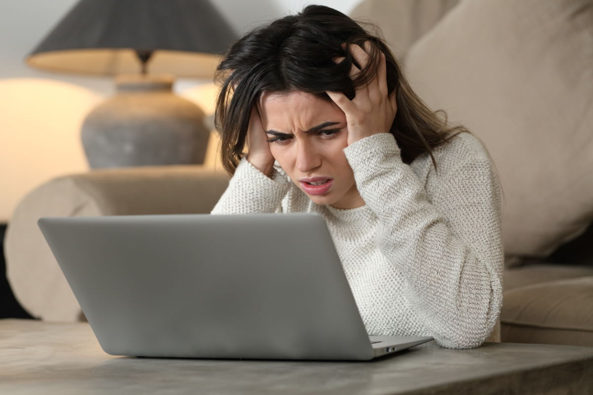 Desperate woman checking bad news on laptop Desperate woman checking bad news on laptop