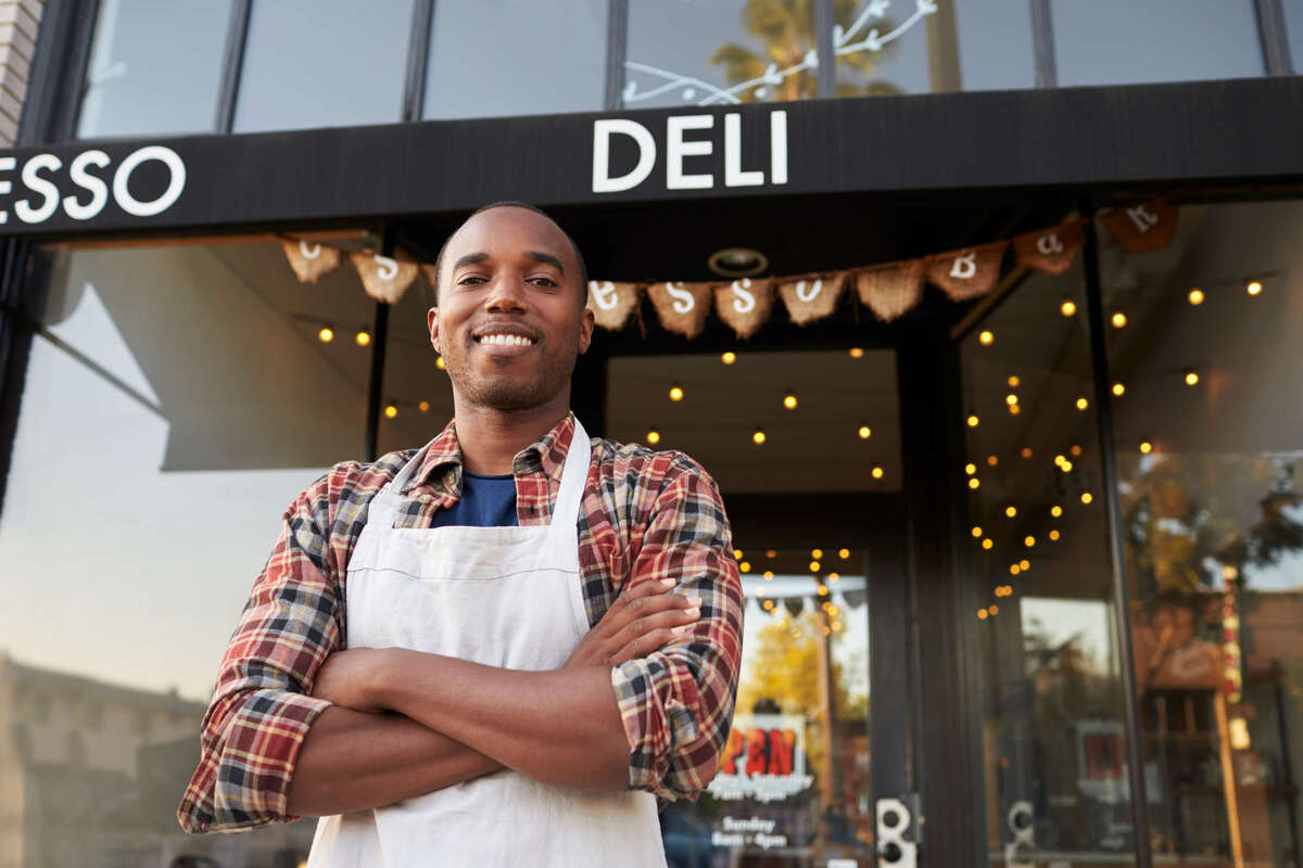 Black male business owner standing outside coffee shop